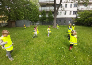 Dzieci bawią się na ukwieconej trawie.