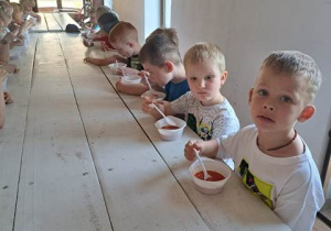 Dzieci jedzą zupę pomidorową.