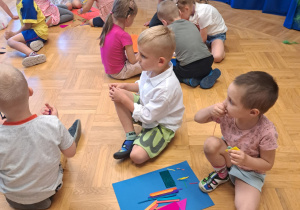 Dzieci w zespołach 3-4 osobowych wykonują plakat do bajki Pinokio z przygotowanych materiałów plastycznych- kolorowy papie, patyczki,kolorowe sznurki.