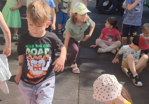 Zabawy dzieci z najmłodszej grupy przy muzyce w ogrodzie przedszkolnym .