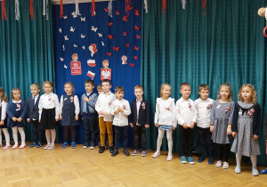 Dzieci z najstarszej grupy w galowych strojach śpiewają piosenkę o Polsce.