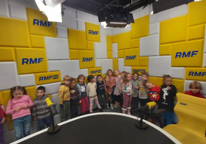Dzieci stoją na tle ścianki reklamowej z napisami RMF FM.