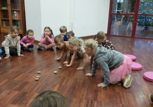 Dzieci siedzą na podłodze i grają w jedną z azjatyckich gier.