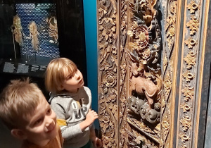 Dwoje dzieci ogląda azjatyckie rzeźbienia .