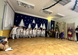 Występ dzieci z grupy 5 latków. Dziewczynki ubrane są w białe peleryny, jest też Trzech Króli i pastuszkowie.