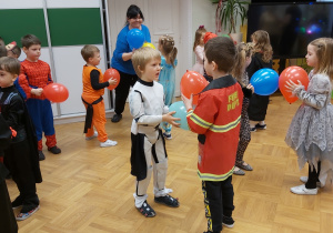 Dzieci podczs balu tańczą w parach z balonami.