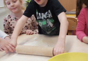 Chłopiec wałkują ciasto.