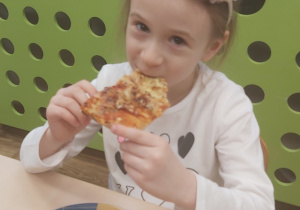 Dziewczynka je pizzę