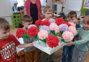 Chłopcy wręczają koleżankom własnoręcznie wykonane kwiatki.