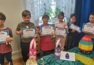Dzieci prezentują przyiesione prace oraz otrzymane nagrody.