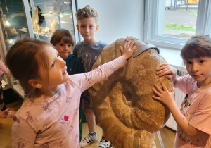 Dziewczynki stoją obok wielkiej "kamiennej muszli".