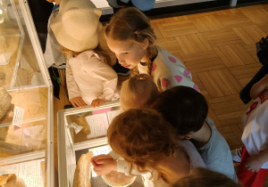 Dzieci oglądają eksponaty w muzeum.
