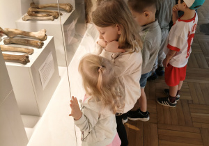 Dzieci oglądają eksponaty w muzeum.