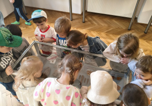 Dzieci oglądają eksponaty w muzeum.