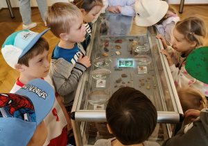 Dzieci oglądają eksponaty w muzeum.
