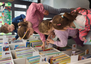 Dzieci oglądają zbiory biblioteczne.
