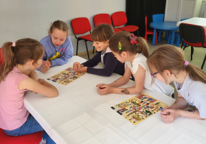 Dziewczynki układają puzzle o tematyce afrykańskiej.