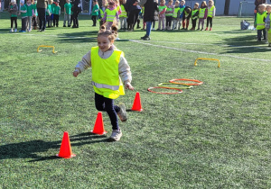 Dziewczynka pokonuje slalom między pachołkami.