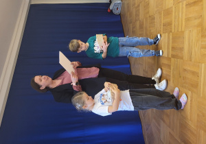 Pani Dyrektor wraz z dwójką dzieci rozdaje pamiątkowe dyplomy.