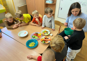 Ciocia daje dziecku do spróbowania jednego z warzyw
