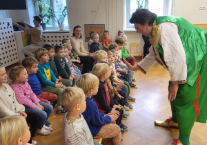 Klaun wita się z dziećmi "przybijając piątkę".
