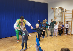 Kilkoro dzieci idzie po linie rozłożonej na podłodze.