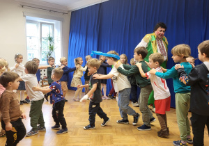 Dzieci tworzą pociąg za klaunem.