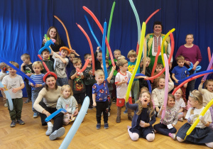 Dzieci pozują do zdjęcia grupowego z klaunem.