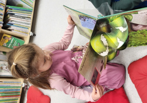 Dziewczynka ogląda trójwymiarową książkę o zwierzętach