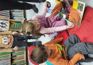 Dzieci oglądają trójwymiarową książkę o zwierzętach.