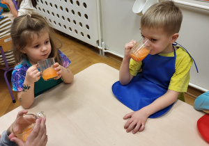 Dzieci piją wykonany własnoręcznie zdrowy sok.