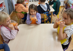 Dzieci piją wykonany własnoręcznie zdrowy sok.