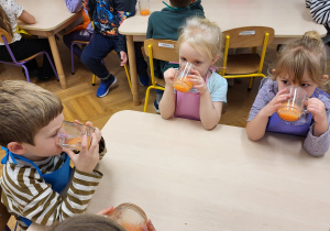 Dzieci piją wykonany własnoręcznie zdrowy sok.