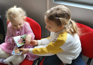 Dwie dziewczynki oglądają ilustracje przedstawiające różne przyprawy.