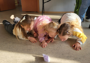 Trzy dziewczynki dmuchając przesuwają łódkę z pieprzem.