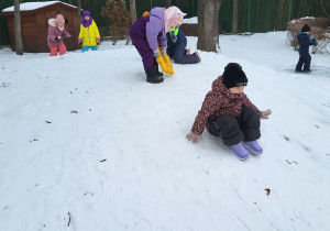 Dziewczynki zjeżdżają z górki.