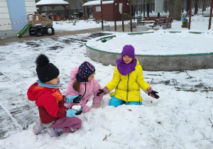 Dziewczynki bawią się na śniegu.
