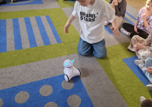 Chłopiec bawi się robotem.