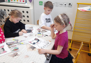 Dzieci wykonują pracę plastyczną - sylweta kota.