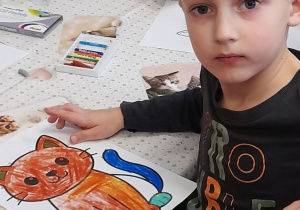 Chłopiec prezentuje swoją pracę - kota.