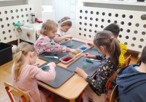 Dzieci barwią wodę na różne kolory.