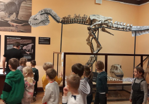 Dzieci oglądają szkielet dinozaura.