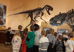 Pracownik muzeum opowiada dzieciom o zbiorach muzealnych.