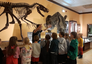 Pracownik muzeum opowiada dzieciom o zbiorach muzealnych.