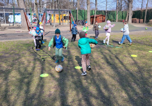 Dzieci wykonują ćwiczenia z piłką.