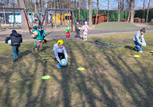 Dzieci wykonują ćwiczenia z piłką.