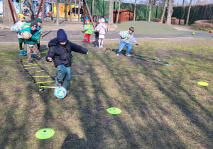 Dzieci wykonują ćwiczenia z piłką.