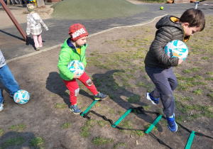 Dzieci wykonują ćwiczenia z piłką.