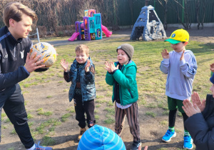 Dzieci uczą się podrzucać i łapać piłkę.