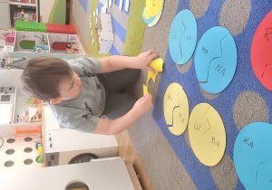 Chłopiec układa wyrazy składające się z dwóch sylab.